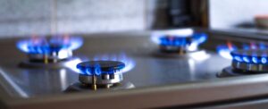 Close-up of a blue fire from a kitchen stove. 4 gas burners with a burning flame. wide banner